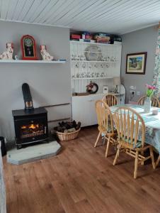 een eetkamer met een tafel en een open haard bij Maggies Cottage in Manorhamilton