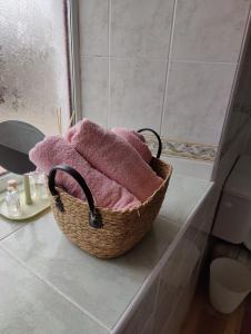 una cesta de toallas sentada en una encimera en el baño en Maggies Cottage, en Manorhamilton
