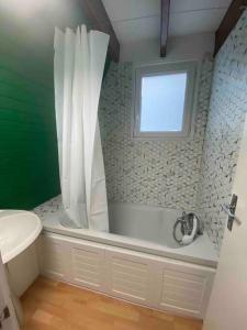 uma casa de banho com uma banheira e uma janela em Chalet L Atypic em Eyne