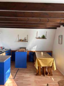 a kitchen with blue cabinets and a table with a yellow table cloth at Chalet L Atypic in Eyne