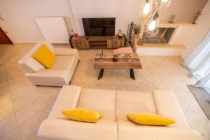 a living room with a white couch and yellow pillows at Iasonas House 85m2 in Preveza