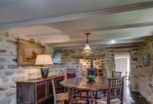 a dining room with stone walls and a table and chairs at Tregadjack Farmhouse in Crowan