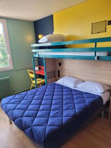a blue bed in a room with a bunk bed at Premiere Classe Lyon Nord Dardilly in Dardilly