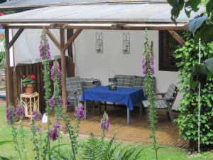 a table and chairs under a pergola with purple flowers at Am Klecker Wald, Ferienhaus in Jesteburg
