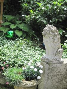 a statue of a lion sitting in a garden at Am Klecker Wald, Ferienhaus in Jesteburg