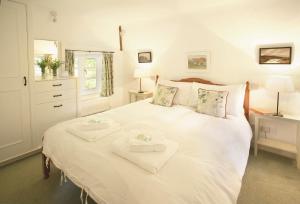 a bedroom with a white bed with two towels on it at Magna Cottage in Ashmore