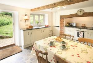 eine Küche mit einem Tisch und einem Tischtuch darauf in der Unterkunft Magna Cottage in Ashmore