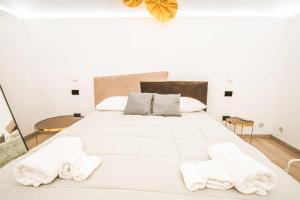 - une chambre avec un grand lit blanc et des serviettes dans l'établissement Malià Sea House, à Bari