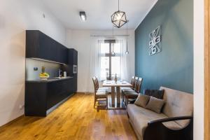 een woonkamer met een bank en een tafel met stoelen bij Bridge Apartments 6 in Krakau