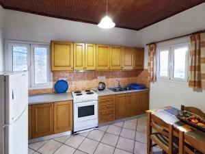 a kitchen with wooden cabinets and a white stove top oven at Villa Elena in Kalami