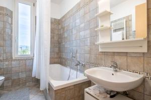 a bathroom with a tub and a sink and a bath tub at -Villa Emily- Parking, Garden & Wi-Fi in Pisa