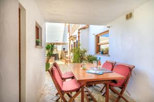 a wooden table with pink chairs in a room at Casa Torres in Pollença