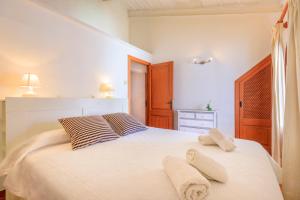 a bedroom with a large white bed with towels on it at Casa Torres in Pollença