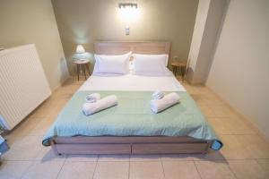 a bedroom with a bed with two towels on it at Iasonas House 85m2 in Preveza