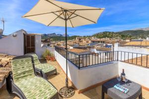 a balcony with a table and chairs and an umbrella at Casa Torres in Pollença