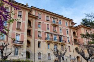 ein großes rosafarbenes Gebäude mit Fenstern und Balkonen in der Unterkunft Ancona e Riviera Luxury b&b in Ancona