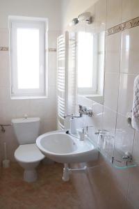 Baño blanco con lavabo y aseo en B&B Hotel Volčík, en Mariánské Lázně