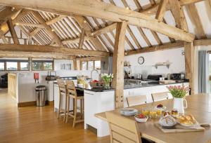 an open kitchen and dining room with wooden beams at Wall Hills Barn in Bromyard