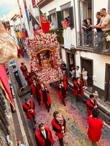 a group of people standing around a float in a parade at DMCharme in Ponta Delgada