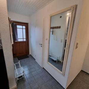 a mirror on the wall of a room with a bathroom at Haus Kaiser Ferienwohnung und Appartementvermietung in Büsum