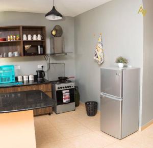 a kitchen with a stainless steel refrigerator and a stove at Cozy Nest Wi-Fi, Netflix call:0707070617 in Eldoret