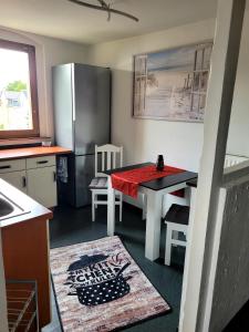 a kitchen with a table and a refrigerator at gemütliche Ferienwohnung in Burgstaedt