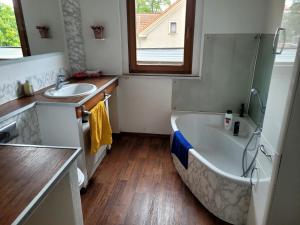 a bathroom with a tub and a sink and a bath tub at gemütliche Ferienwohnung in Burgstaedt