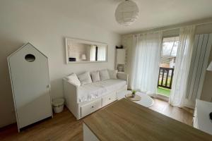 un soggiorno con divano bianco e finestra di Appartement Pereire ad Arcachon