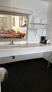 baño con lavabo y espejo grande en A Wyoming Inn, en Cody