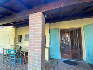 d'une terrasse avec une porte, une table et des chaises. dans l'établissement Podere Bellavista in campagna, à Gabbro