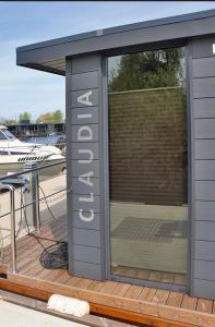 a building with a sign on a deck with a boat at Hausboot La Mare Claudia in Weyhe