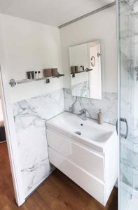 a white bathroom with a sink and a mirror at Hausboot La Mare Claudia in Weyhe
