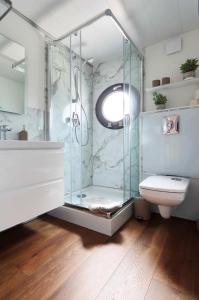 a bathroom with a glass shower and a toilet at Hausboot La Mare Claudia in Weyhe