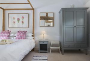 a bedroom with a bed and a blue cabinet at Hampton Wafre Cottage in Leominster