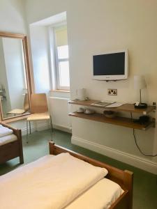 a bedroom with a bed and a desk with a computer monitor at Thornhill Inn in Thornhill