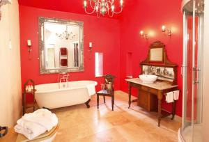 a red bathroom with a tub and a sink at Scargill Castle in Barningham