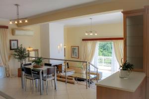 a kitchen and living room with a table and chairs at Villa Kyriaki in Kalami
