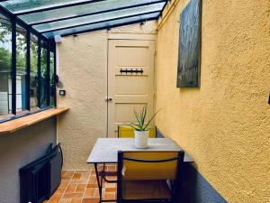 une table avec une plante en pot sur le côté d'un bâtiment dans l'établissement Le Mimosa, Maison-Jardin dans Rennes- 2 chambres, à Rennes