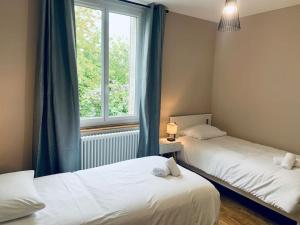 - 2 lits dans une chambre avec fenêtre dans l'établissement Le Mimosa, Maison-Jardin dans Rennes- 2 chambres, à Rennes