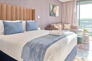 a bedroom with a large bed and a living room at Zimbali Lakes Boulevard Suites in Ballito +162 photos