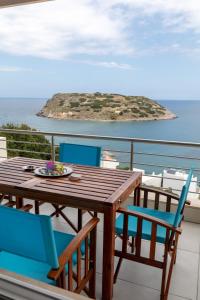 una mesa y sillas en un balcón con isla en Serenity apartment Mochlos, en Mókhlos