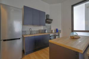 a kitchen with a refrigerator and a wooden counter top at Boulevard de la Plage flat in Arcachon