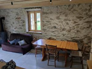 a living room with a wooden table and a couch at CHEZ FLORENT ET CELINE in Queige