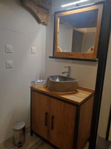 La salle de bains est pourvue d'un lavabo et d'un miroir sur un comptoir. dans l'établissement CHEZ FLORENT ET CELINE, à Queige