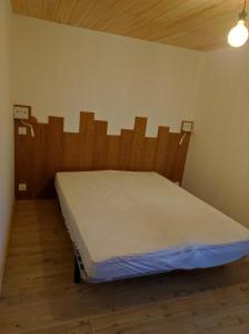 - un lit dans une chambre avec une tête de lit en bois dans l'établissement CHEZ FLORENT ET CELINE, à Queige