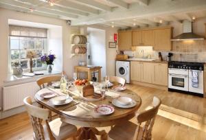 a kitchen with a wooden table with chairs and a dining room at Garth Iwrch in Eglwys-Fâch