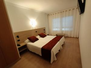 a bedroom with a large white bed and a window at Hotel Vilobi in Vilobí d'Onyar +15 photos