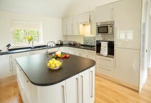 a kitchen with a bowl of fruit on a counter at Brook Lodge Essex in Chappel