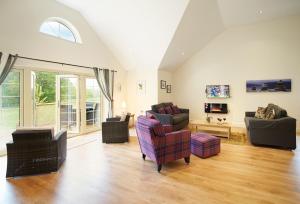 a living room with couches and chairs and a window at Brook Lodge Essex in Chappel