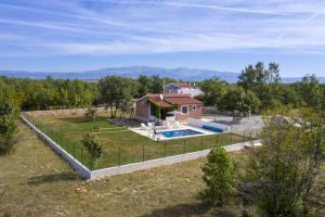 a house with a swimming pool and a fence at Holiday Home Domina in Sinj